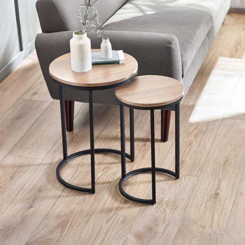 Two wooden side tables with black metal legs in a living room setting.