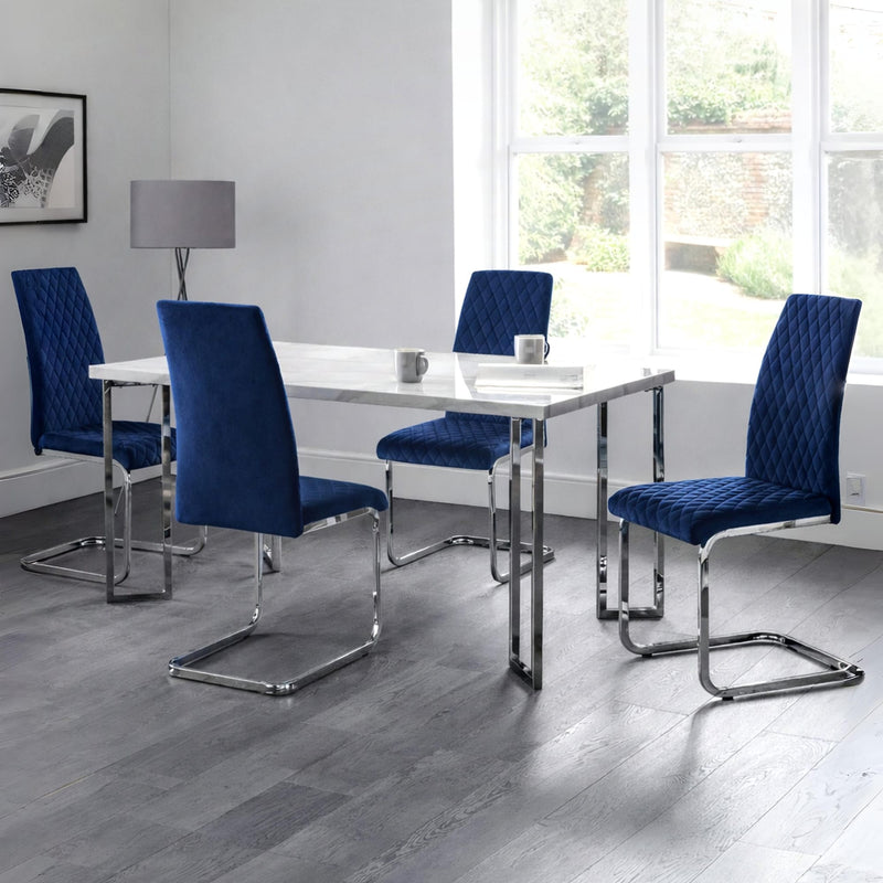 Modern dining room with blue chairs and a white table near large windows.