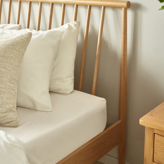Wooden bench with cushions against a neutral wall