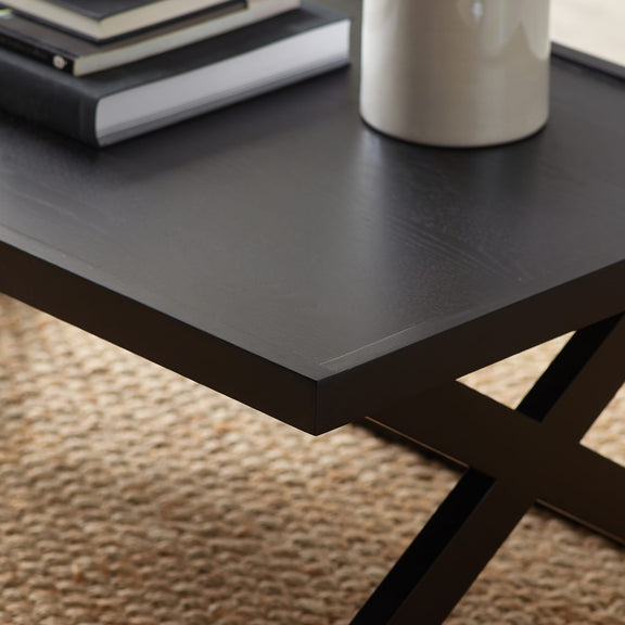 Black metal table with a vase and books on a textured surface