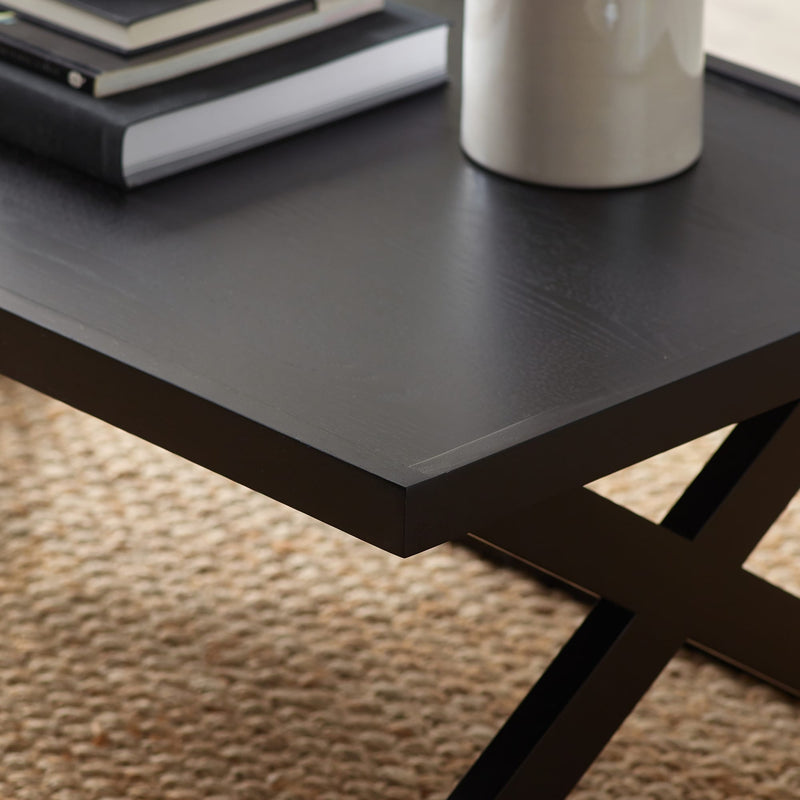 Black metal table with a vase and books on a textured surface