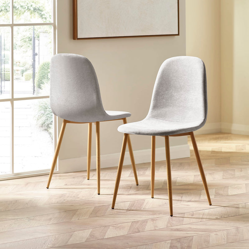 Two gray chairs with wooden legs in a room with a large window.