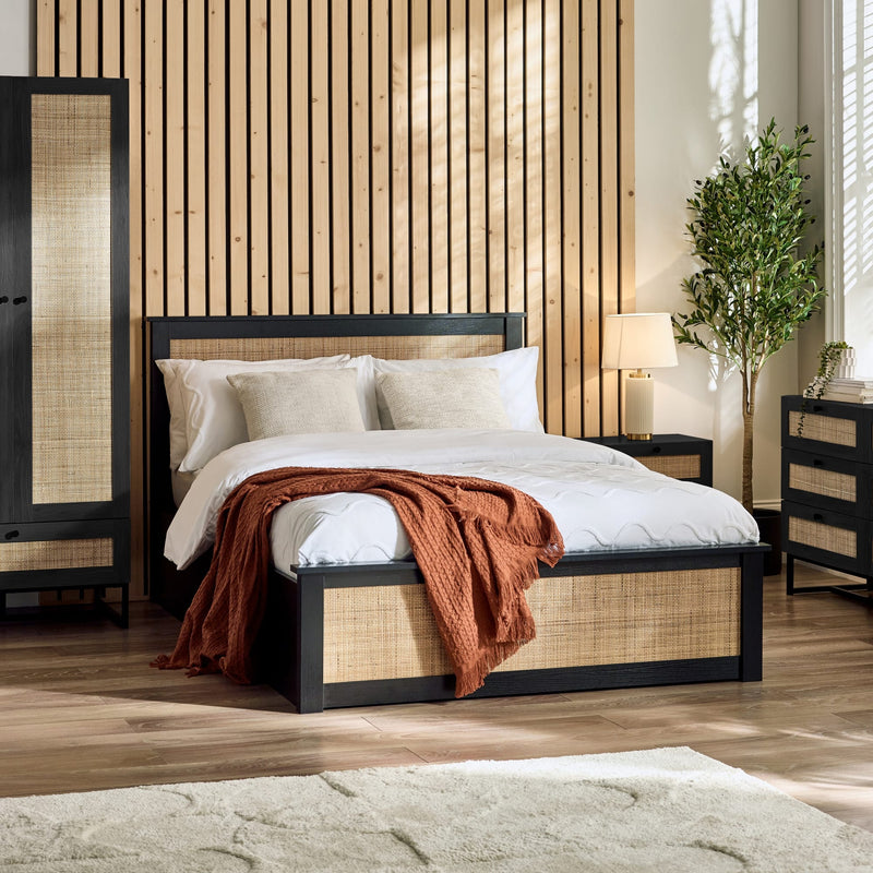 Bedroom with wooden bed frame, white bedding, and decorative elements.