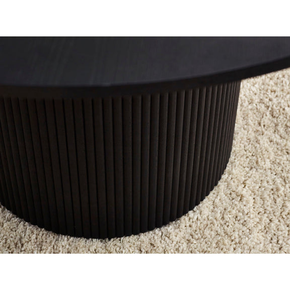 Close-up of a black textured round table on a beige carpet