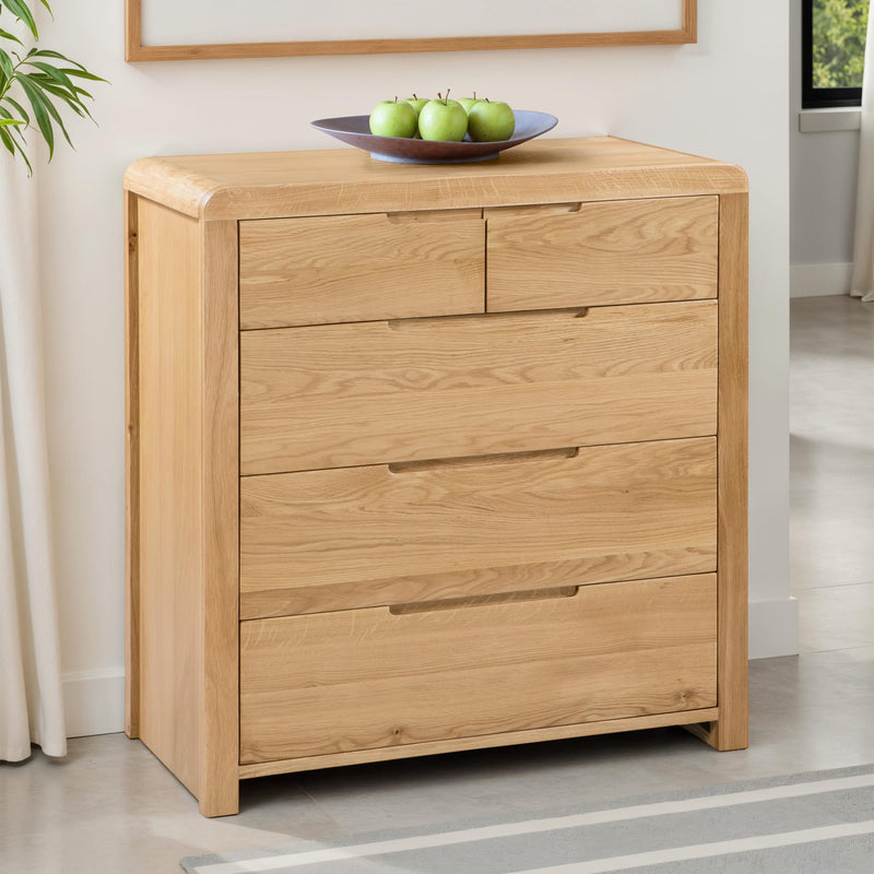 Wooden dresser with four drawers in a room setting.