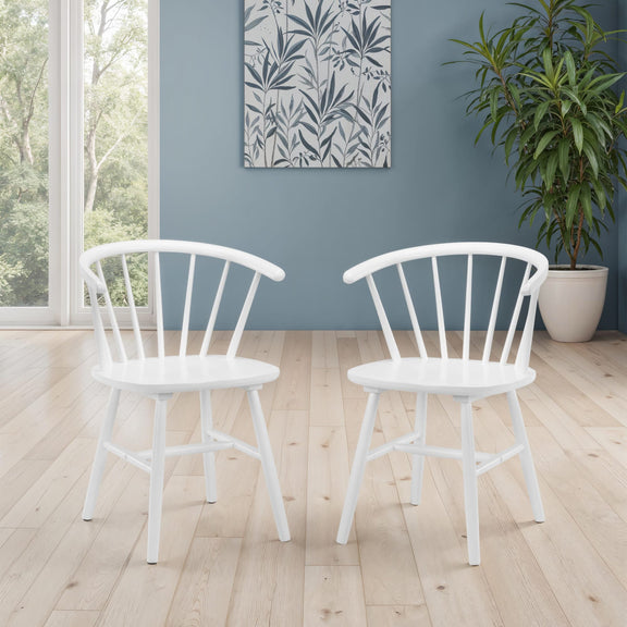 Two white chairs in a room with a blue wall, plant, and window.