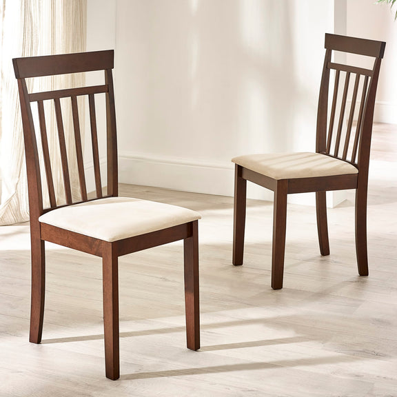 Two wooden chairs with white cushioned seats on a light wooden floor.