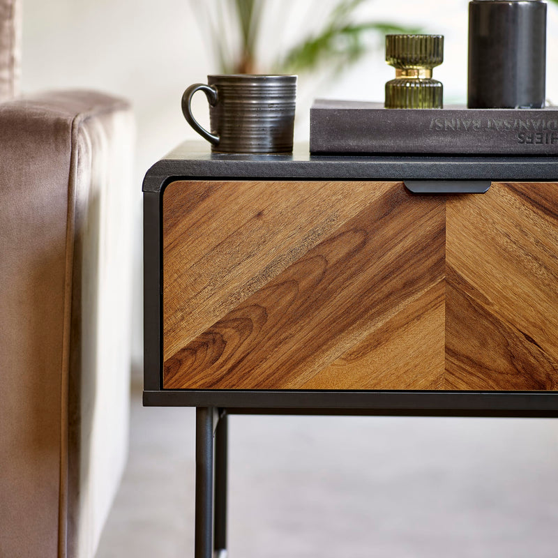 Wooden side table with a coffee cup and books on a blurred background