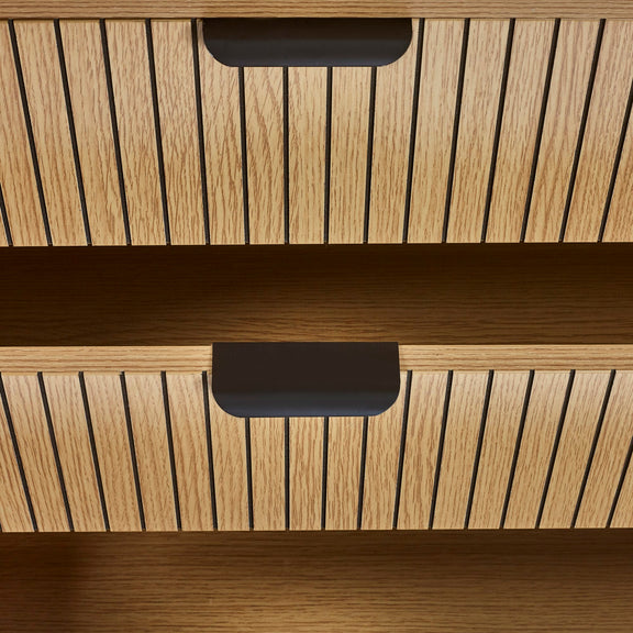 Wooden drawer with black handles on a wooden cabinet