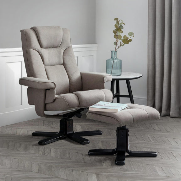 Beige recliner chair with ottoman in a room with a small table and plant.