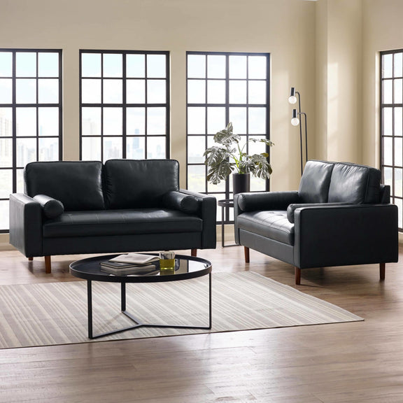 Modern living room with black leather sofa set and glass coffee table.