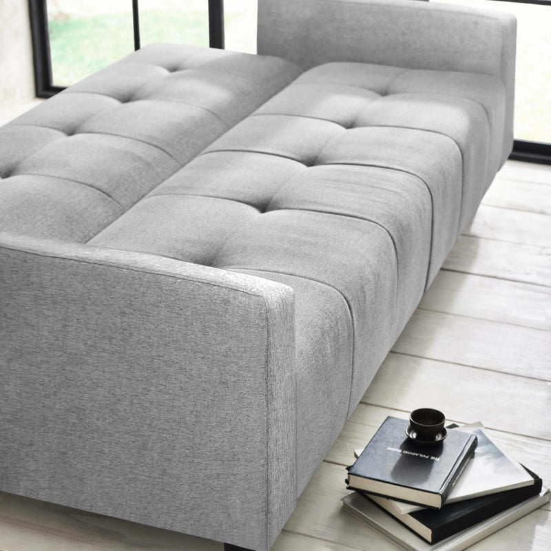 Gray upholstered bed in a room with a window