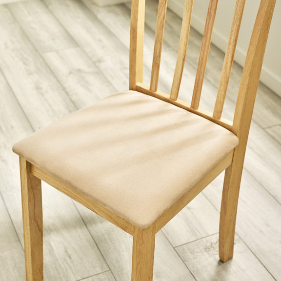 Wooden chair with a beige cushion on a light wooden floor