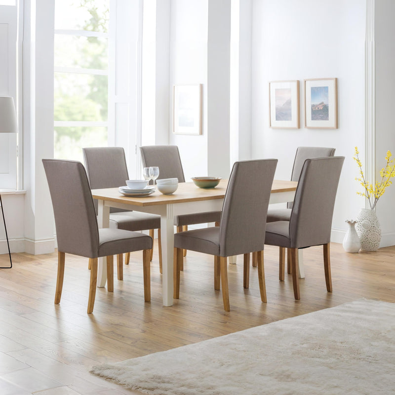 Dining room with a wooden table and gray chairs in a bright room.