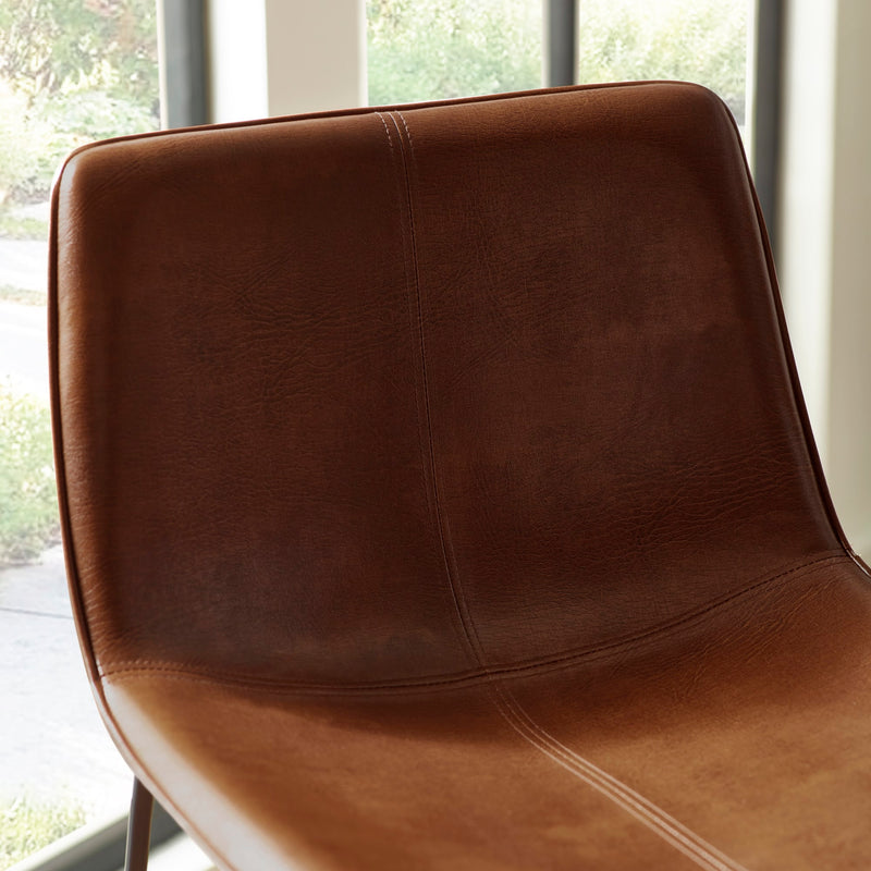 Brown leather chair with a blurred window background