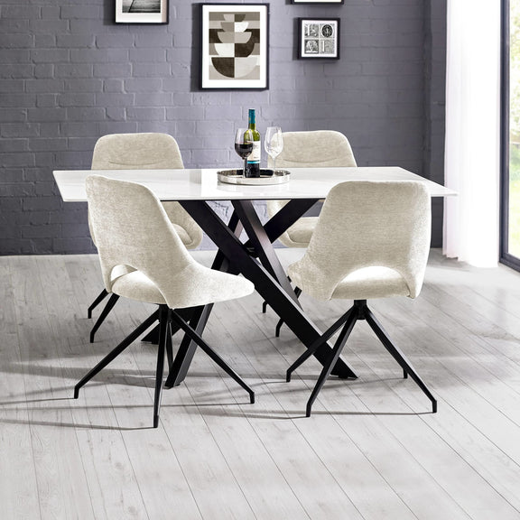 Dining table set with four chairs in a room with gray walls and a window.