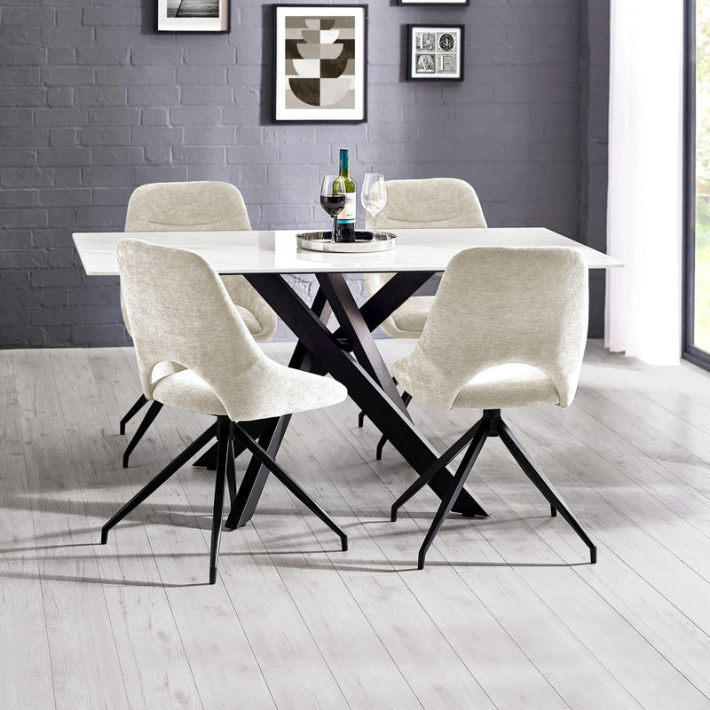 Dining table set with four chairs in a room with gray walls and a window.