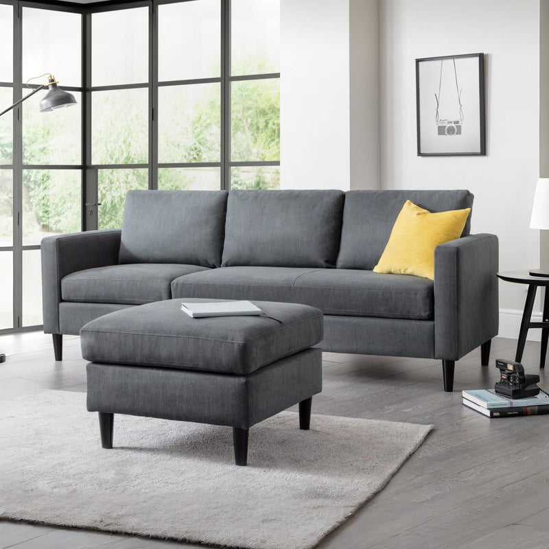 Gray sectional sofa with a yellow pillow in a living room setting.