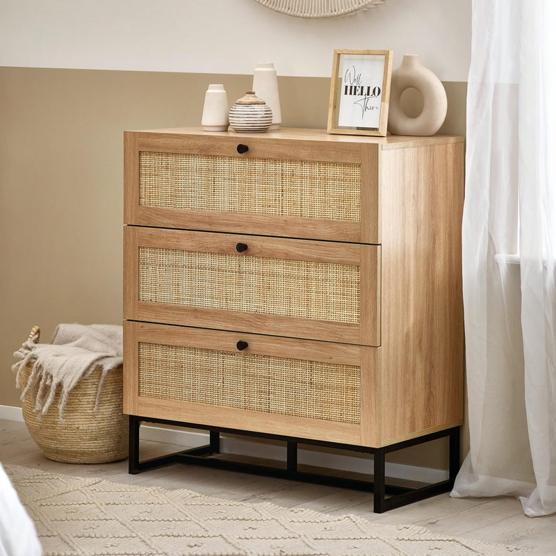 Wooden dresser with wicker drawers in a room setting