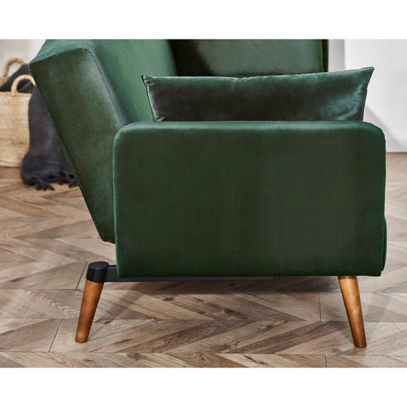 Green armchair with wooden legs on a wooden floor