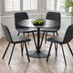 Black round dining table with four matching chairs in a room with large windows.