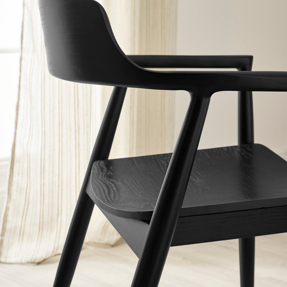 Black chair with a blurred curtain background