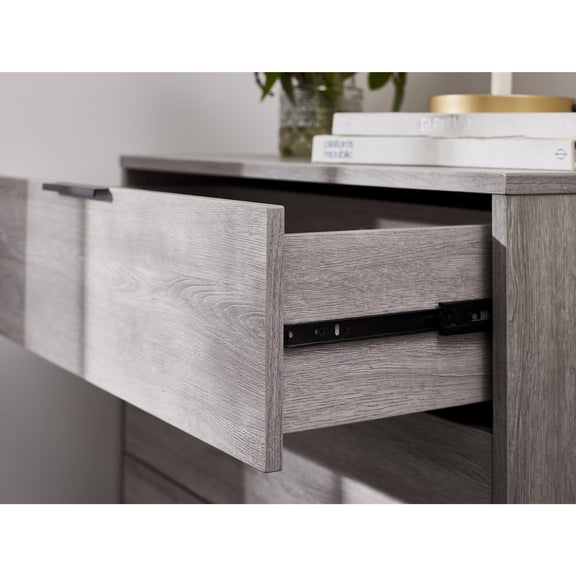 Wooden desk with an open drawer, books, and a plant on top.