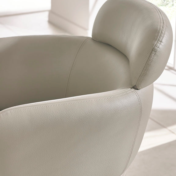 Close-up of a beige leather chair with a blurred background