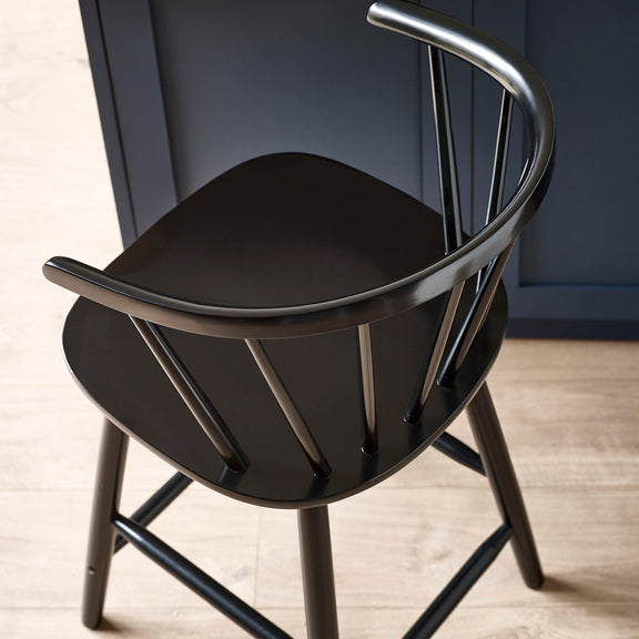 Black wooden chair with curved backrest on a wooden floor.