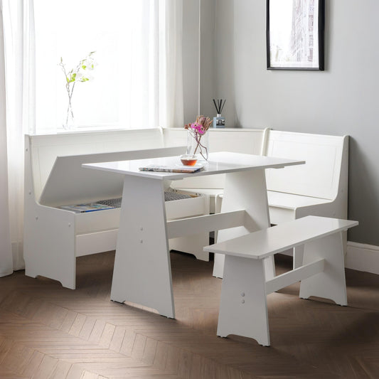 White dining set with table and benches in a room with light gray walls and wooden flooring.