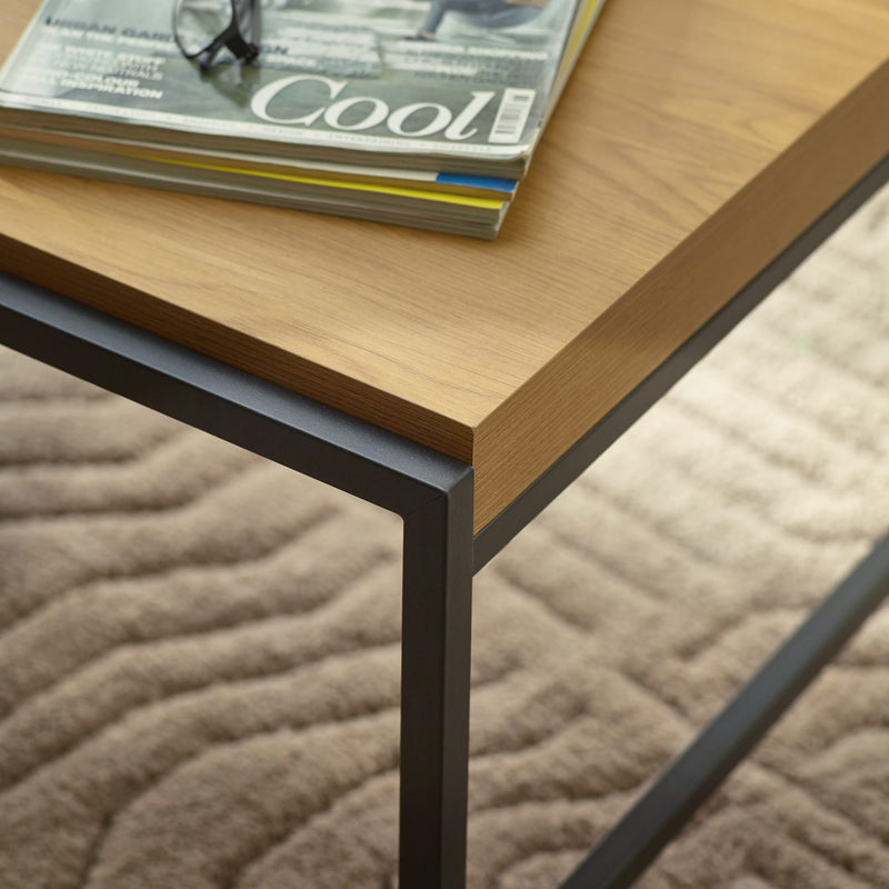 Wooden table with black metal legs on a textured surface