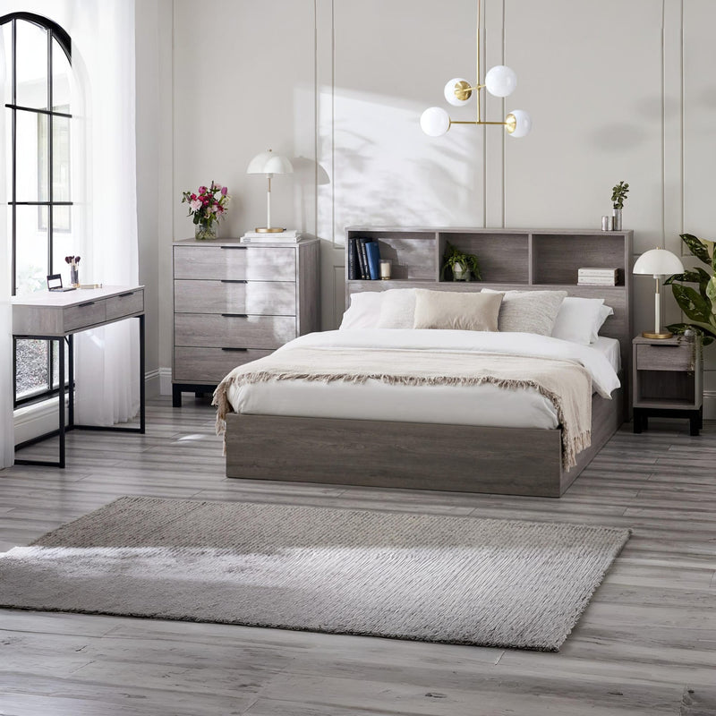 Modern bedroom with gray bed, nightstands, and a desk.