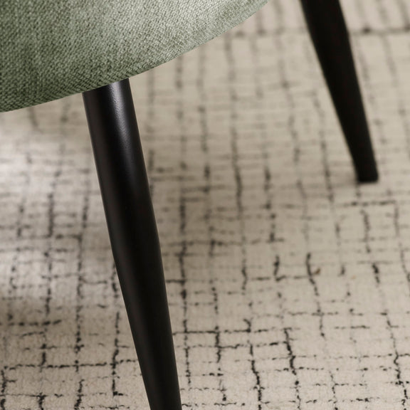 Close-up of a chair leg on a textured carpet
