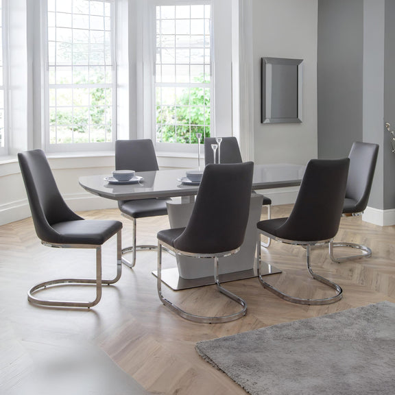 Modern dining room with a glass table and black chairs.