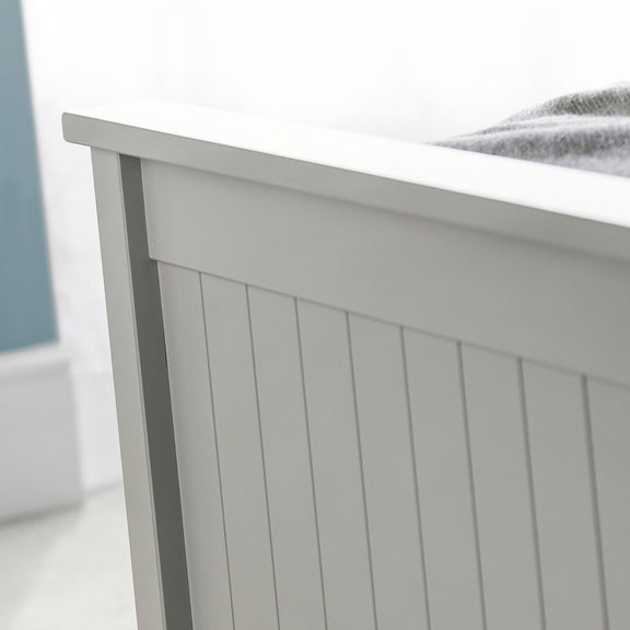 Close-up of a gray wooden bed frame with a white mattress.