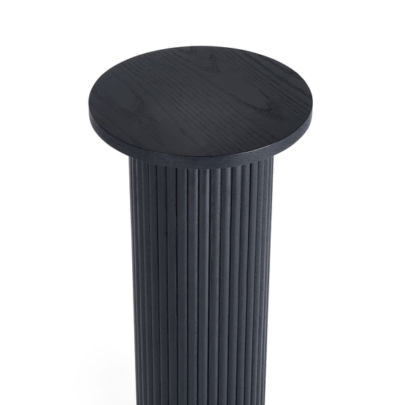 Black cylindrical stool with a ribbed design on a white background