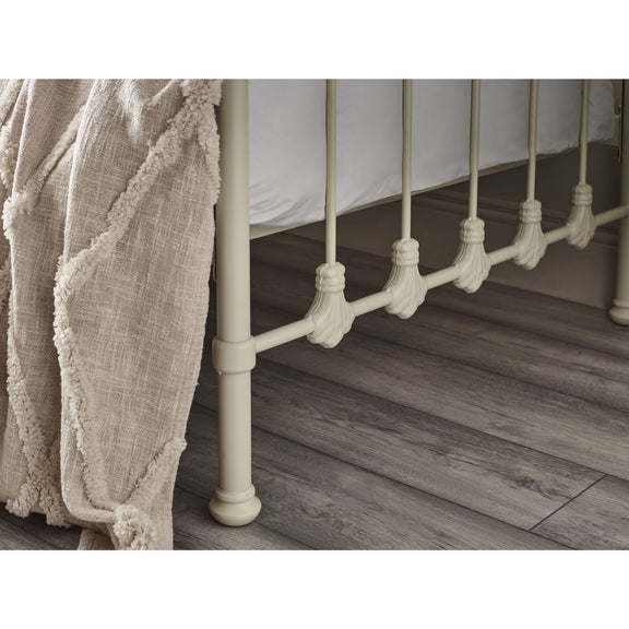 Close-up of a metal bed frame with wooden flooring