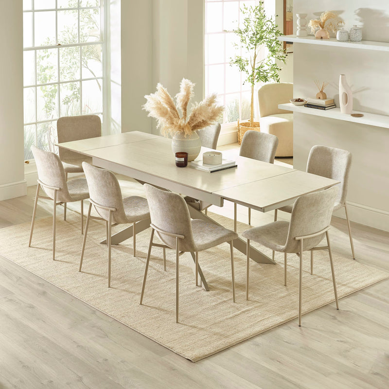 Dining room with a white table and chairs in a bright room.