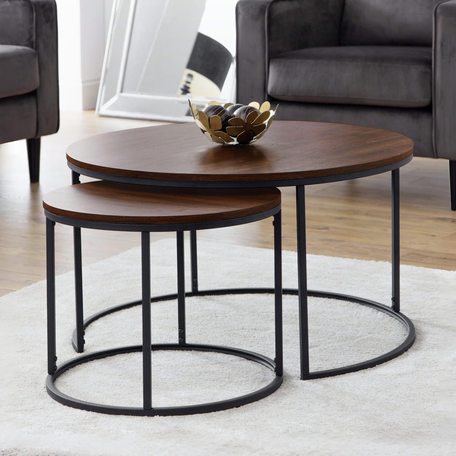 Set of two wooden coffee tables with metal legs in a living room setting.