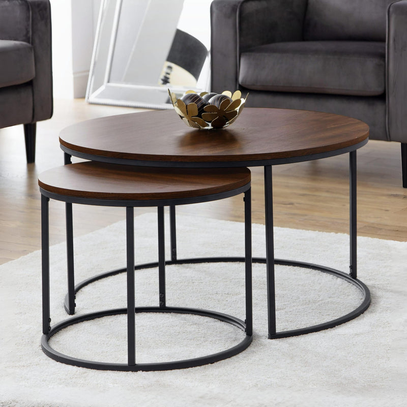 Set of two wooden coffee tables with metal legs in a living room setting.