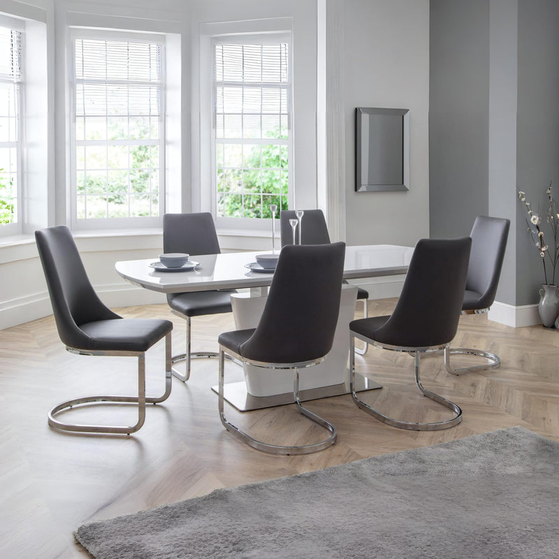 Modern dining room with a white table and black chairs in a well-lit room.