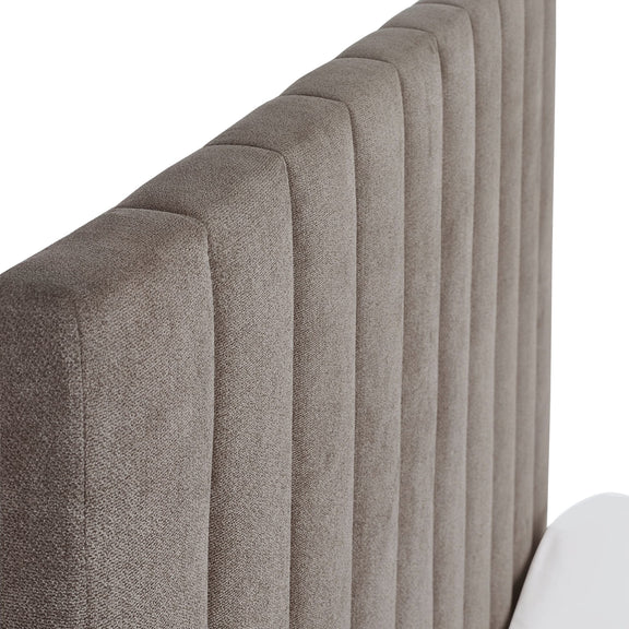 Close-up of a textured headboard with a neutral color on a white background