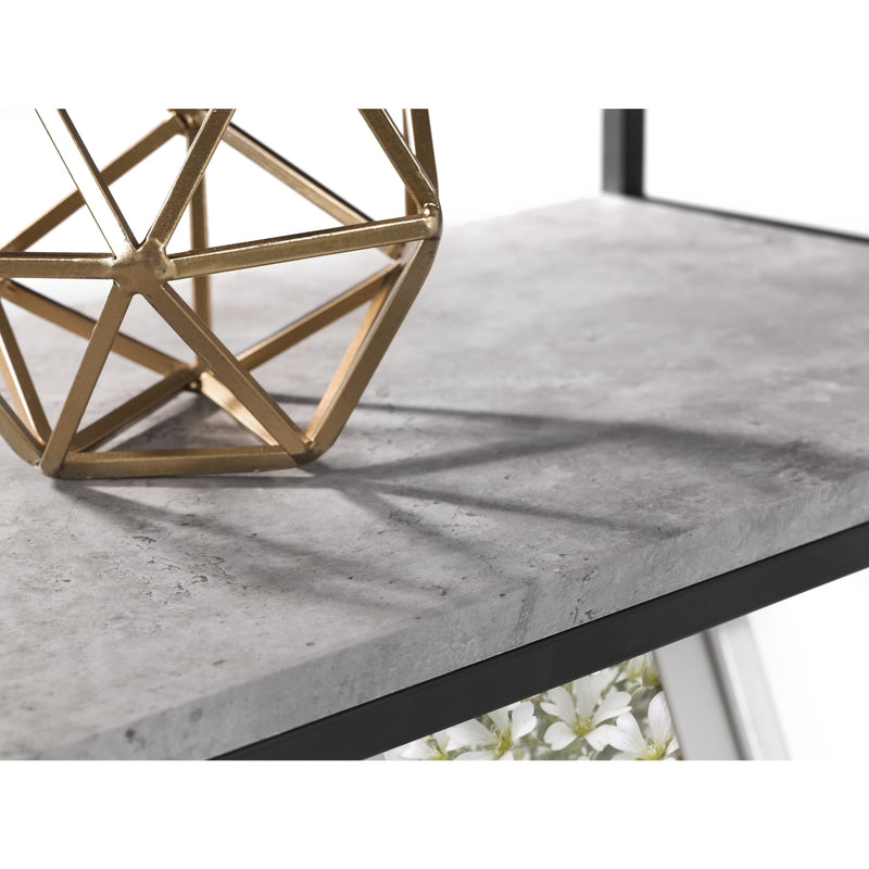 Gold geometric sculpture on a gray marble surface with a white background
