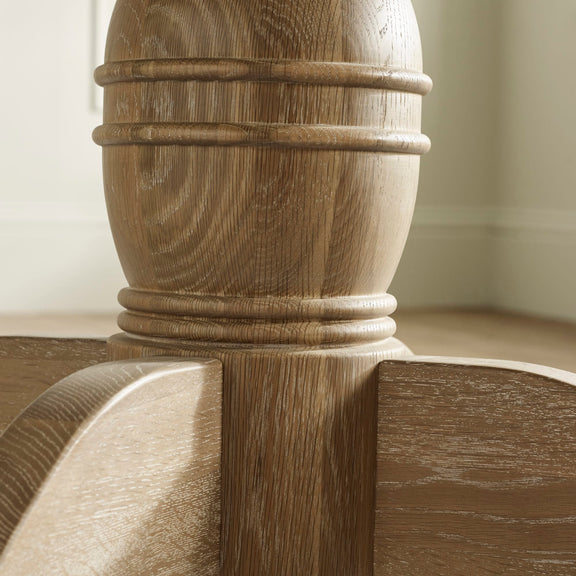 Close-up of a wooden column with detailed carvings against a neutral background