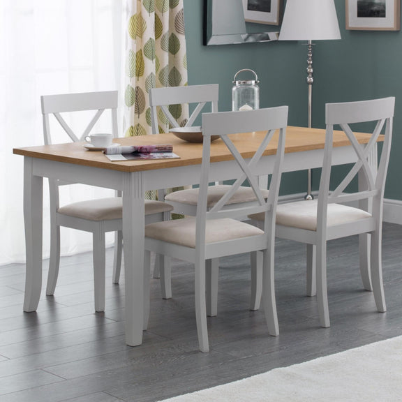 Dining room with a wooden table and white chairs against a green wall.