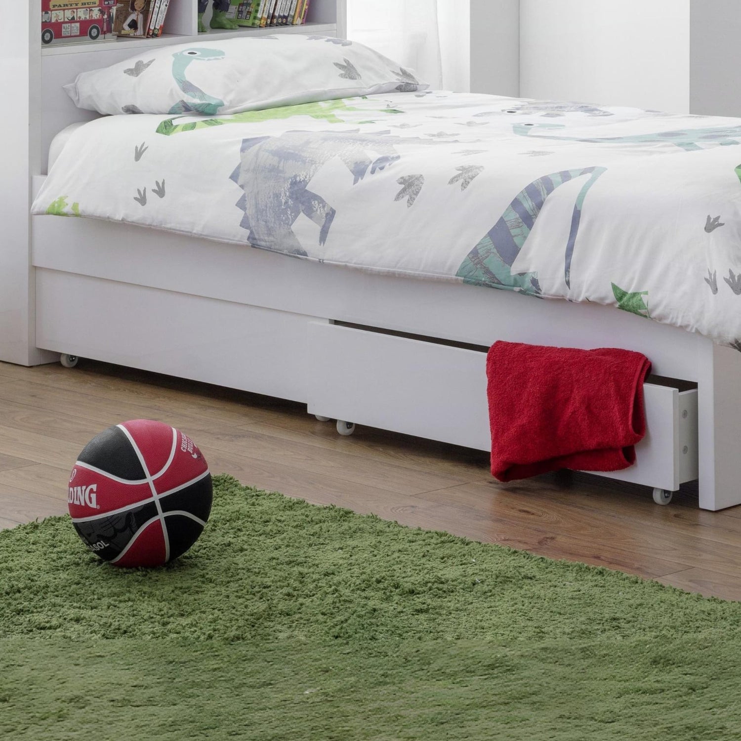 Children's bedroom with a bed, basketball, and green rug.