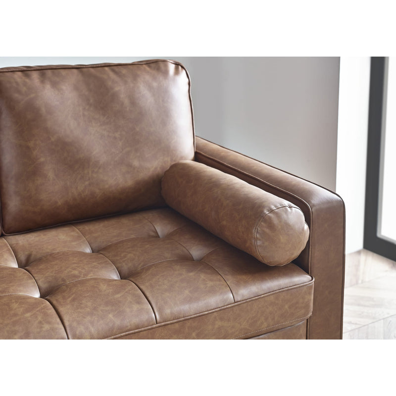 Brown leather sofa in a minimalistic room with a light gray wall.