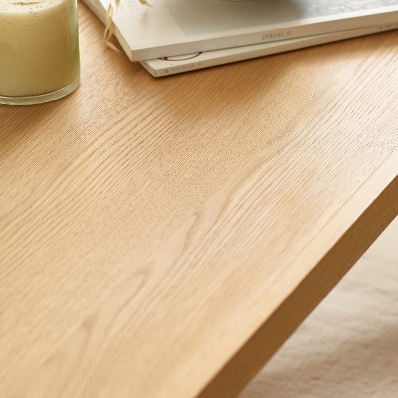 Close-up of a wooden desk surface with a glass of green liquid on it.
