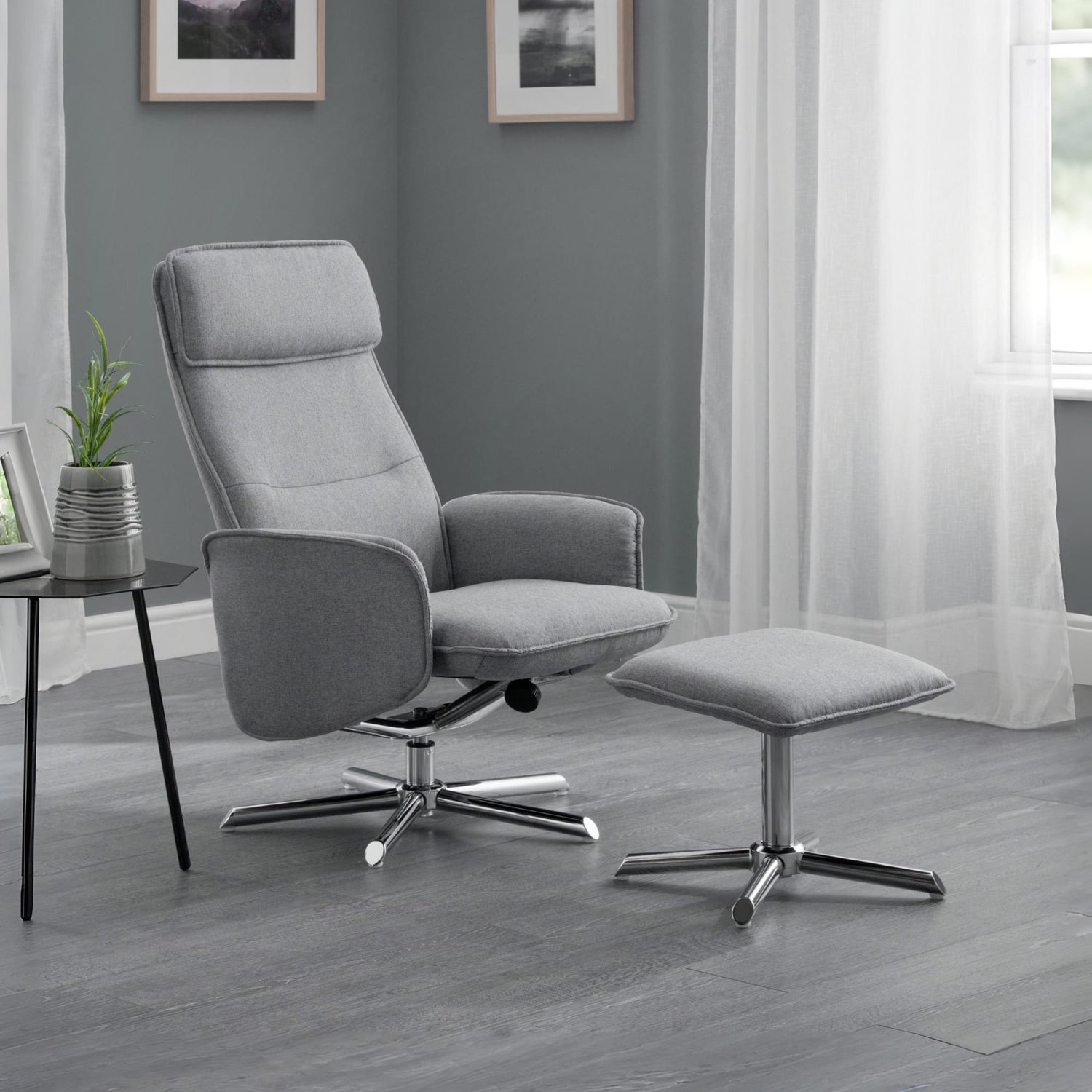 Gray recliner chair with ottoman in a room with gray walls and white curtains.