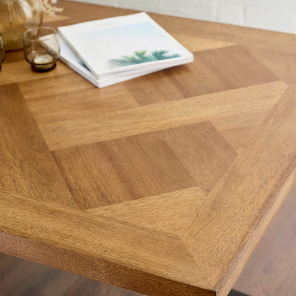 Wooden table with geometric pattern and a book on top